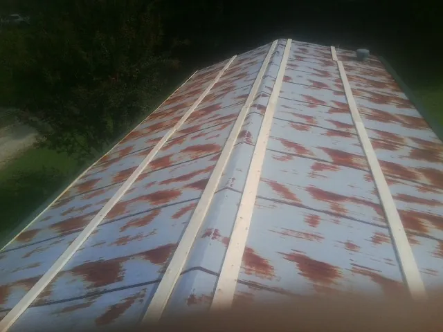 Rusted metal roof panels with new wood purlins before replacement — Storm Damage Roof Repair in Frederick by Roofing Brothers