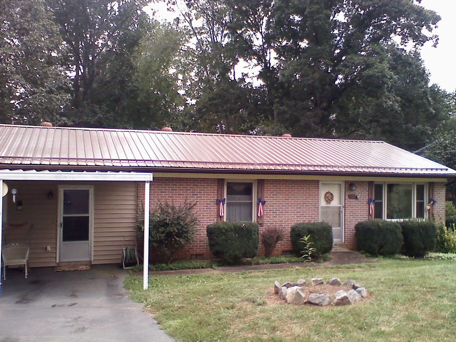 Bronze metal roof and carport on a brick ranch home — Roof Repair work by our crew in Frederick